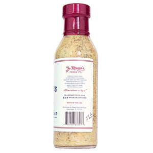 A 12-ounce bottle of YO MAMA'S - CREAMY ITALIAN DRESSING by YO MAMA'S FOODS, featuring a red cap and a white label with blue and red text. The label proudly states that the dressing is gluten-free, dairy-free, and contains no added sugar. Specks of seasoning are visible in the creamy dressing.