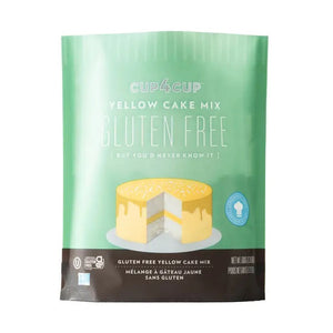 A green and brown package of Cup4Cup Gluten Free Yellow Cake Mix. The top features an illustration of a sliced yellow cake with white frosting. Text on the package reads, "Gluten Free, But You'd Never Know It," made with non-GMO ingredients. Certified Kosher, the net weight is 23 ounces.
