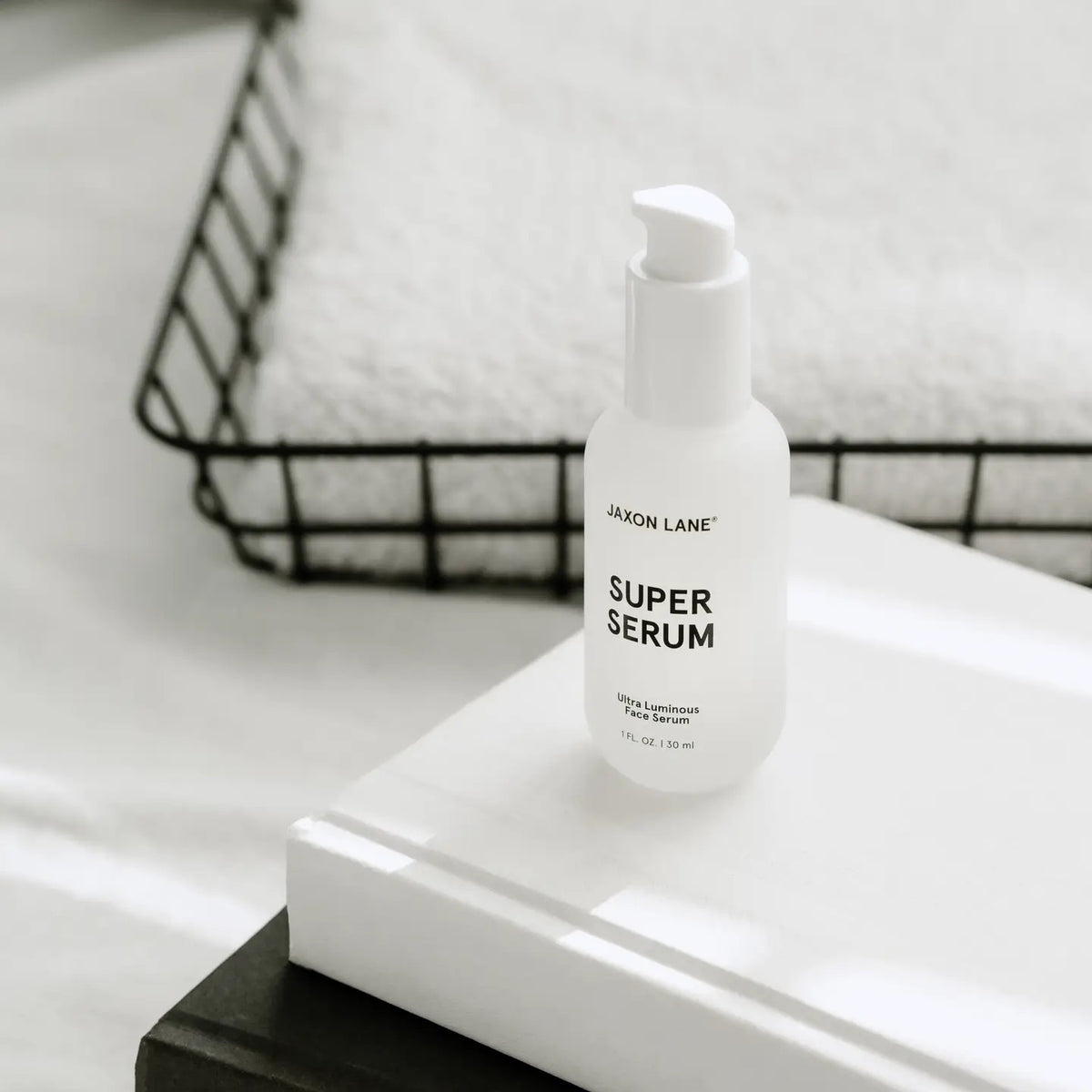 A white bottle labeled &quot;JAXON LANE - SUPER SERUM ULTRA LUMINOUS FACE SERUM FOR MEN,&quot; 1 fl oz / 30 ml, with a white cap stands upright on a plain white background—ideal for men seeking a brightening serum with niacinamide.