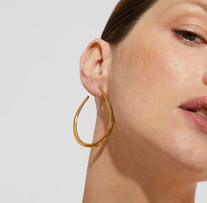 A pair of GAS BIJOUX BOBO earrings displayed on a plain white background. The elegant gold-plated teardrop hoops are thin and feature a smooth finish, embodying a minimalist design.