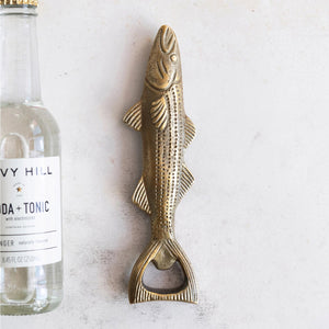 The FISH SHAPED BOTTLE OPENER by CREATIVE COOP is a coastal-inspired accessory with an antique gold finish, showcasing intricate scale patterns on its body, fins, and tail. It features a horizontally oriented design where the tail fin serves as the functional opener, with its head facing left.