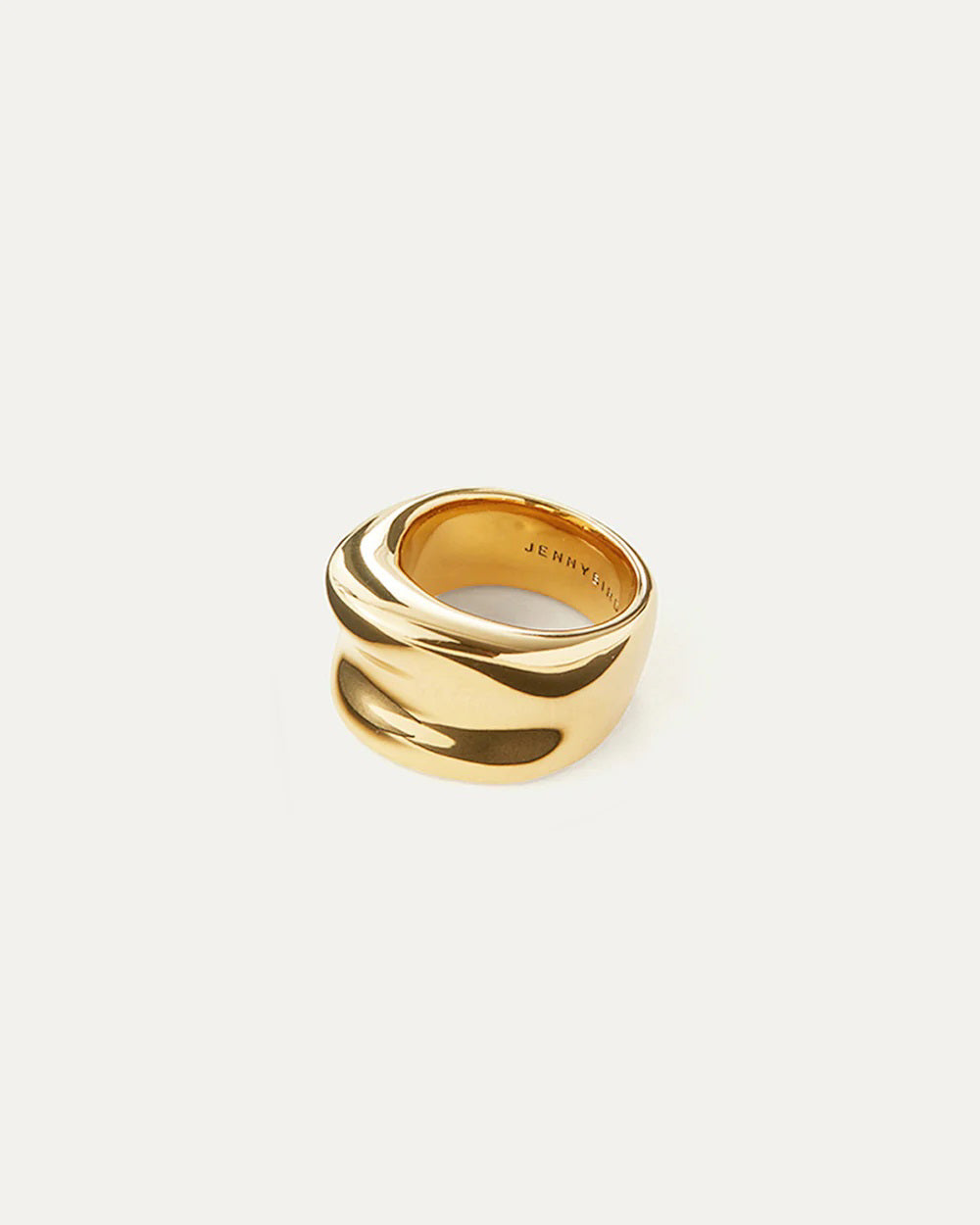 The JENNY BIRD - VIVIANA RING is a versatile accessory flaunting a wide silver band and an elegant, smooth, wavy design. The inner side of the ring is engraved with "JENNYVI," while the backdrop remains plain and light-colored.