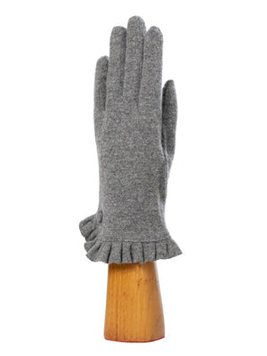 A green, wool knit glove from Santacana Madrid World Glove Company is showcased upright on a wooden hand-shaped stand, featuring a simple pleated trim around the wrist.