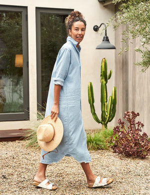 The FRANK & EILEEN Rory Maxi Shirtdress in Famous Denim is a full-length button-up dress featuring a collar, rolled-up sleeves to mid-length, and a single chest pocket. Its sleek, minimalist design embodies that California chic look against a plain white textured background.