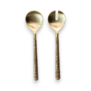 A set of two STAINLESS STEEL SALAD SERVERS WITH RATTAN HANDLES from CREATIVE COOP, featuring a regular spoon and a forked spoon, both elegantly crafted in brass and showcased against a pristine white background.