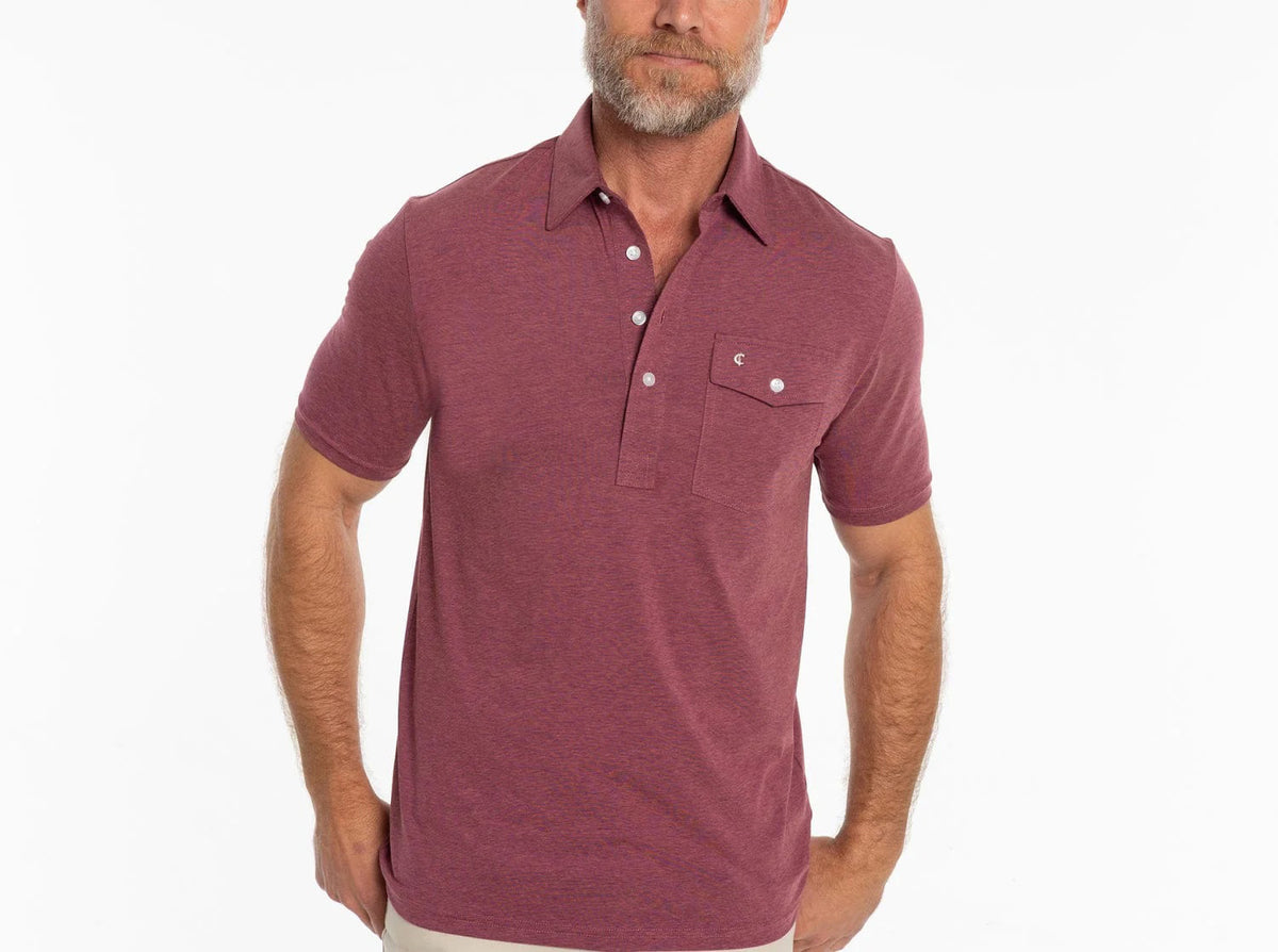 A bearded man wears the CRIQUET Performance Players Shirt in Birdie Juice—a short-sleeve, moisture-wicking polo with a buttoned chest pocket—standing against a plain white background.