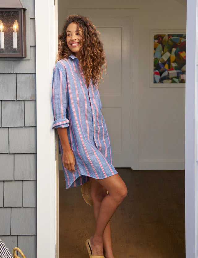 The FRANK AND EILEEN - MARY CLASSIC SHIRTDRESS IN RED NAVY STRIPE by FRANK & EILEEN is a long-sleeved, knee-length shirt dress with a collar, featuring vertical blue and red stripes. The sleeves are rolled up to three-quarter length. This best-selling shirtdress is a four-seasons favorite.