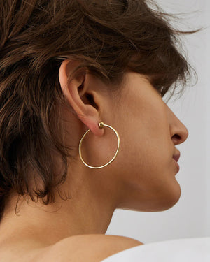 The JENNY BIRD - ICON HOOP EARRINGS SMALL, crafted from high-polish gold stainless steel by JENNYBIRD, offer a minimalist design. Their lightweight, hollow construction includes waterproofing and flexibility for easy opening, while a 360-degree closure prevents hair from catching.