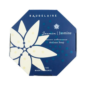 A hexagonal blue box of Baudelaire Jasmine 7 oz Boxed Bath Bar, enriched with shea butter. The box features a large, stylized white flower design and text such as "Jasmine," "Savor artisanaux," "Artisan Soap," and "Made in France.