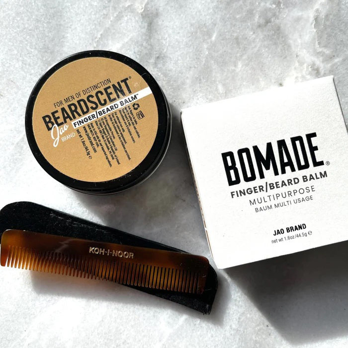 A round tin of moisturizing beard balm with a black lid, labeled "BEARDSCENT" by "JAO LIMITED," catered for "men of distinction." Adorned with a gold label featuring black and white text, it details the product ingredients, including essential oils. The brand name "Jao" highlights it as a versatile finger and beard balm.