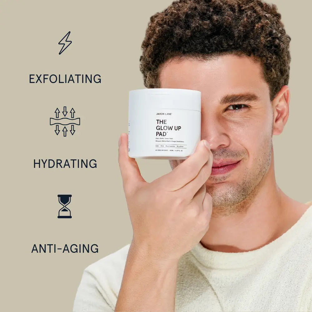 A white jar labeled JAXON LANE - GLOW UP PAD DAILY DETOX TONER PADS sits with a clear tweezer in front of a textured pad. These hydrating, biodegradable pads contain AHA, PHA, niacinamide, and rice bran.