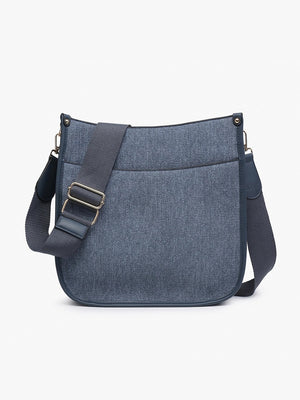 The JEN & CO DENIM CROSSBODY WITH GUITAR STRAP showcases a trendy gray fabric, black trim, adjustable guitar strap, and stylish rectangular shape with rounded corners. It features a front pocket and is set against a plain white background for both style and functionality.