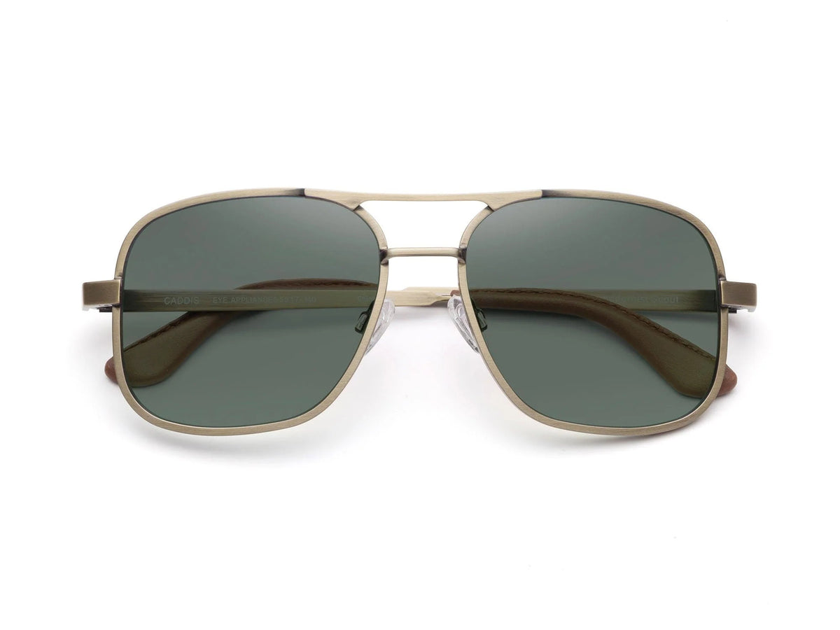 Front view of CADDIS - METAMODERNIST SCOUT SUNGLASSES by CADDIS, featuring an aviator-style sleek metal alloy frame and dark green premium tinted lenses, displayed on a white background.