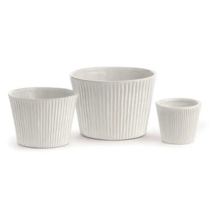 Three white ceramic Sinclair Cachepots from Napa Home and Garden are displayed side by side. Each cachepot features a ribbed texture on the exterior. The largest is in the middle, with the medium-sized one on the left and the smallest on the right, offering contemporary selections for a sleek look and modern touch to your kitchen.