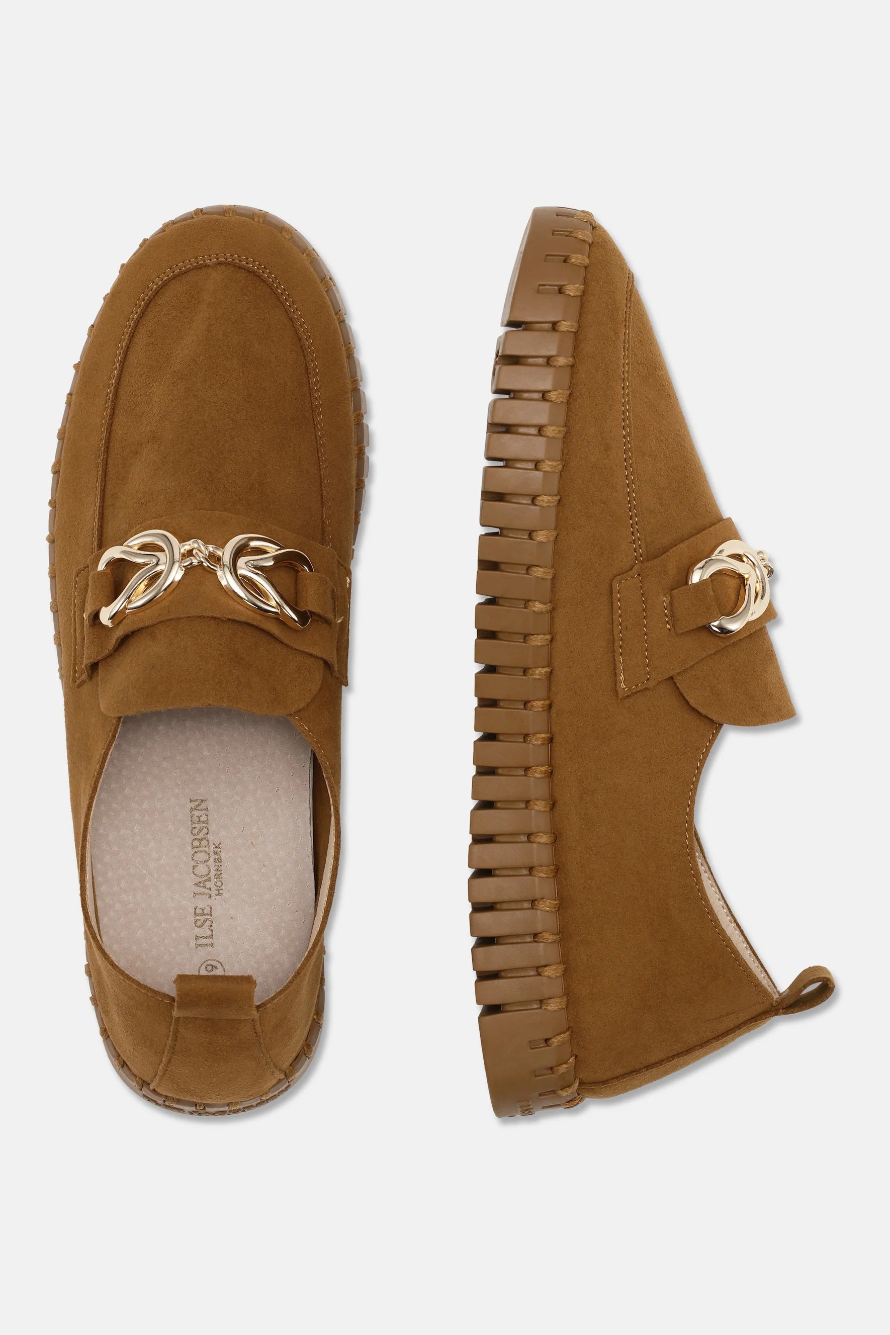 A pair of brown suede Tulip Loafers with a decorative gold-look chain detail on top from Ilse Jacobsen, by Lines of Denmark. The shoes feature a chunky, ribbed rubber sole for added style and durability. Made with recycled microfiber, the insole of the left shoe is visible, showing the brand name "Steve Madden".