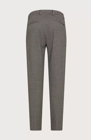 The SEVENTY Slim Fit Ankle Length Jacquard Vichy Stretch Pant is displayed from the back. These sophisticated, tailored pants feature a high waist and buttoned back pockets, with a slightly tapered leg fit. Made from textured fabric reminiscent of gingham jacquard, these ankle-length trousers embody both style and elegance with their black and white houndstooth pattern.