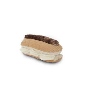 A plush toy named the "LAMBWOLF COLLECTIVE - ECLAIR DOG TOY" by LAMBWOLF COLLECTIVE sits on a white background. The toy features multiple textures with light brown "pastry" sides, a dark brown "chocolate" top, and white "cream" filling, mimicking the appearance of a real snuffle eclair dessert.