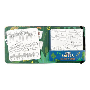 The cover of the FLOSS AND ROCK - DINOSAUR MAGIC WATER COLOR IN CARDS features vibrant dinosaur-themed water cards set in a lush jungle with plants and trees. The title "Magic Water Colour-In Cards" stands out prominently, accompanied by translations in various languages underneath. Suitable for ages 3 and up, these cards come conveniently packaged in a travel-friendly bag.