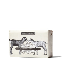 A bar of BEEKMAN - PURE GOAT MILK SOAP BAR 9OZ by BEEKMAN - STA ELEMENTS, a natural triple-milled soap, in cream-colored packaging with black illustrations of two goats facing each other. The packaging notes that this moisturizing soap is fragrance-free, sulfate-free, and paraben-free.