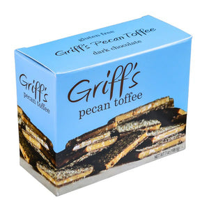 A blue box of GRIFF'S TOFFEE - PECAN TOFFEE 7OZ, proudly labeled "Gluten Free," features an image of dark chocolate pecan toffee pieces. With a net weight of 7 ounces (198.5 grams), this delicious treat from GRIFFS TOFFEE combines the richness of dark chocolate with the crunch of pecans for a delightful snack.