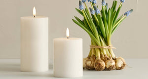 The PIFFANY UYUNI - IVORY PILLAR CANDLE 3X4 features a gentle flickering 3D flame atop a smooth, cylindrical wax surface and includes remote control functionality for tailored ambiance against a white background.