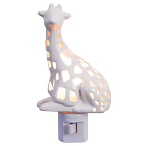 The GIRAFFE NIGHTLIGHT by LILY'S LIGHTS plugs into a wall outlet, featuring a hollow ceramic design with geometric cutouts that allow light to shine through. Its minimalist and decorative look, especially against white-painted walls and outlets, makes it a unique gift for any occasion.