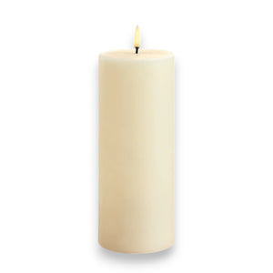 A tall UYUNI - IVORY PILLAR CANDLE 3X6 by PIFFANY features a realistic 3D flame that flickers gently at the top against a plain white background.