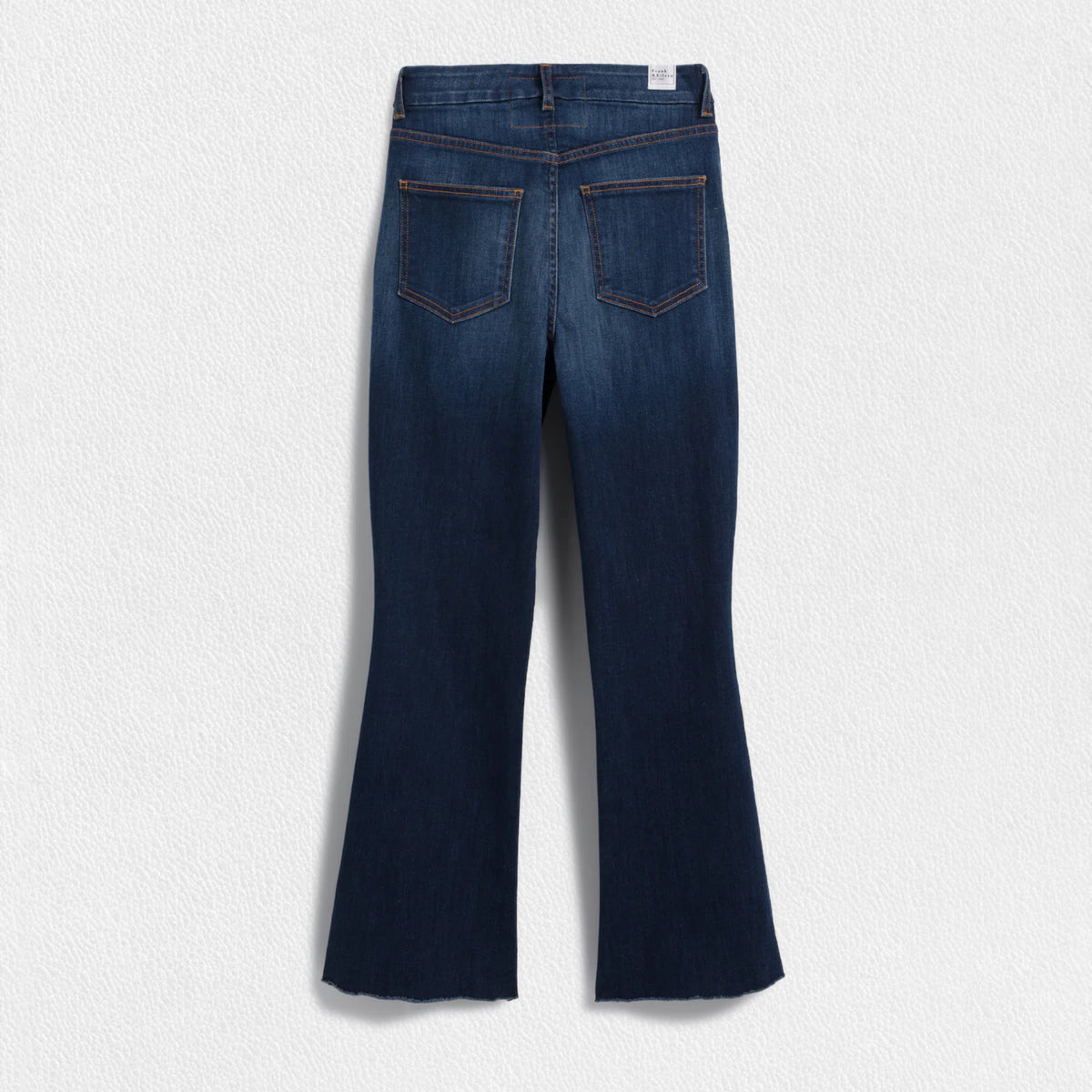 A pair of FRANK &amp; EILEEN - Killian Crop Flare Jeans is displayed flat against a textured white background. Made from soft denim with power stretch, they feature a classic five-pocket design, belt loops, and a button and zip closure. The high-rise legs are slightly flared, offering a clean, modern appearance.