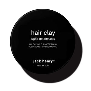 JACK HENRY - HAIR CLAY: A black circular container with white text, delivering all-day hold, volumizing matte finish, and hair-strengthening benefits to support growth. Size: 1.6oz / 50ml.