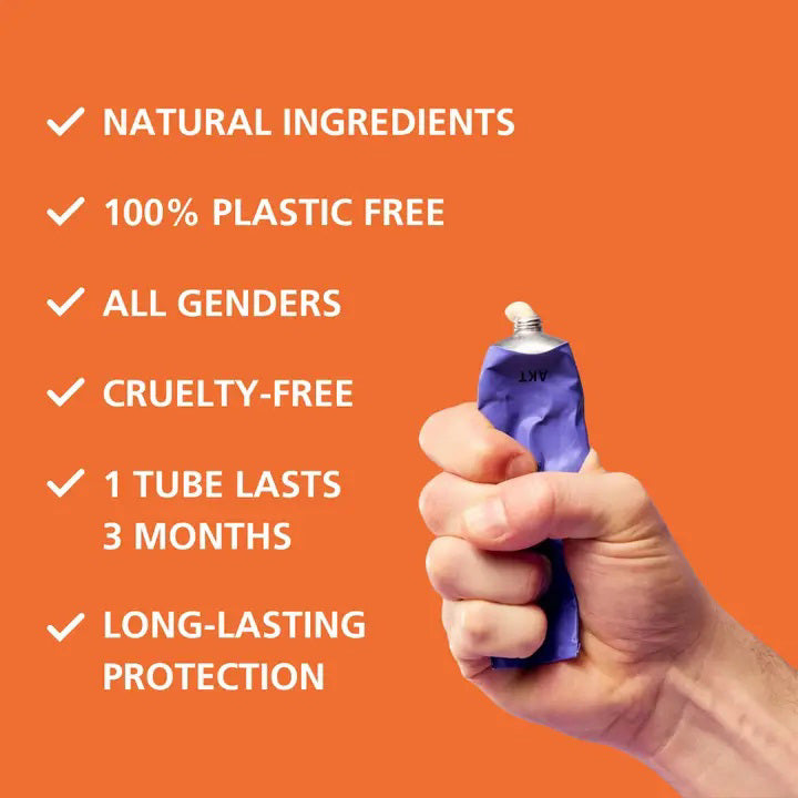 A purple tube of AKT LONDON’s AKT DEODORANT BALM THE ONSEN, a vegan and aluminum-free deodorant, stands by its box on a beige surface with matching background. Minimal packaging showcases black text and product details.