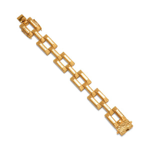 A close-up view of the CAPUCINE DE WULF - PATHWAY LINK BRACELET, GOLD showcases its handcrafted rectangular, textured links connected in a bold geometric pattern. This 18K gold bracelet features a shiny finish and clasp closure from the esteemed brand, CAPUCINE DE WULF.