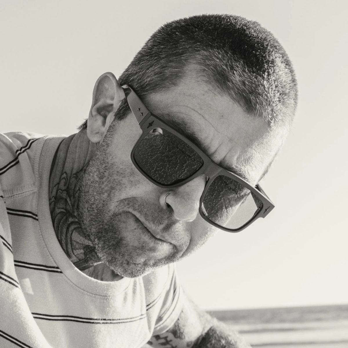 Front view of CADDIS - MISTER CARTOON matte black square sunglasses with dark lenses, premium acetate frame, and &quot;CADDIS&quot; branding inside the left arm.