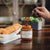 A jar of STONEWALL KITCHEN - DULCE DE LECHE SAUCE is shown. The label describes it as gluten-free, weighing 369 grams (13 oz), and it is renowned for its specialty foods. Perfect for baking, the jar has a green lid, and the sauce inside appears caramel-colored.