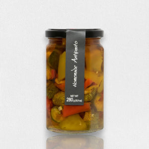 A glass jar with a black lid contains Ritrovo's Cascina Rossa - Antipasto della Casa - Sweet & Savory. The jar displays a black label with white text reading "Cascina Rossa - Antipasto della Casa - Sweet & Savory" and indicates a net weight of 280 grams (9.9 oz). The contents include an assortment of Italian antipasto vegetables.