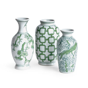 The NAPA HOME AND GARDEN - IMPERIAL BUD VASE, featuring green geometric and floral patterns, sits on a golden tray. Each handcrafted piece holds delicate peonies on a wooden table, beautifully illuminated by soft natural light filtering through the window.