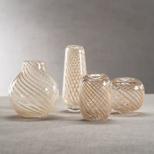 The CLAIRE BUD VASE WITH BEIGE SWIRL - ROUND by ZODAX features a delicate spiral pattern of beige and white lines. Its reflective surface and intricate design create a sense of depth and elegance against the plain white background, making it a standout piece in any collection. Dimensions: 4 inches in diameter.