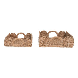 Two woven rectangular baskets with scalloped edges and sturdy handles sit side by side. The baskets feature a natural, rustic look with a textured finish. The left basket, slightly smaller than the right, adds charm reminiscent of the LARGE BRAIDED BANKUAN TRAY WITH HANDLES by CREATIVE COOP.