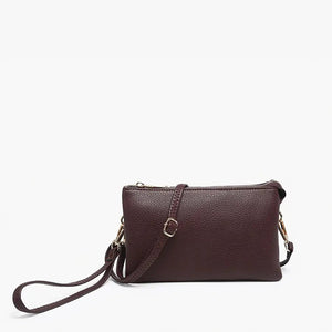 Introducing the JEN & CO 3 COMPARTMENT CROSSBODY WRISTLET: a stylish black wristlet crafted from vegan leather, adorned with elegant gold-tone hardware and equipped with an adjustable strap. The interior features a chic herringbone lining, beautifully displayed against a plain white background.