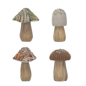 Four delightful mushrooms with fabric tops are elegantly arranged on a wooden base, each varying in height and design. Their earthy tones contrast beautifully with subtle multi-color hues, embodying the Creative Co-Op charm. A rectangular wooden box stands open in the background, while small seeds are artfully scattered around the display.