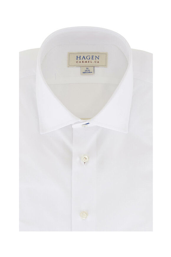 Close-up of the HAGEN - COTTON DRESS SHIRT IN WHITE, neatly folded with a modern spread collar and white buttons. A label inside the collar displays &quot;HAGEN.