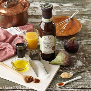 A bottle of STONEWALL KITCHEN-BALSAMIC FIG DRESSING features the product name on a dark bottle with a green label. This delicious gluten-free and non-GMO salad dressing comes in an 11 fl. oz (330 ml) size.