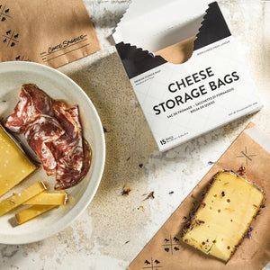 The Formaticum product packaging box for cheese storage bags is perfect for keeping cheese fresh at home. The box has a mainly white design with black accents and text, displaying icons of various cheese shapes. The text reads "FORMATICUM - CHEESE STORAGE BAGS" and indicates that it contains 15 bags.