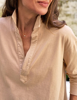 A long-sleeved, light beige FRANK & EILEEN Patrick Popover Henley shirt in Heritage Jersey with a V-neck opening and a cropped hem, laid flat against a white background. The label inside the collar is partially visible, and the shirt appears casual and slightly wrinkled.