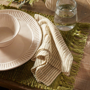 The PRIM NAPKIN by NAPA HOME AND GARDEN offers a neatly arranged set of off-white and beige striped fabric napkins, designed to be machine washable for your convenience. Made from lightweight fabric, these napkins display a simple and elegant pattern of evenly spaced vertical stripes. The set is neatly folded with one napkin draped over the top to showcase their texture and design beautifully.