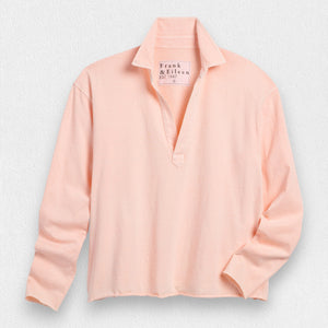 Displayed against a light-colored textured background, this white relaxed-fit long-sleeve top features a slightly open collar and casual v-neck design. The label on the inside of the collar reads "Frank & Eileen," adding to its comfortable appearance. This is the FRANK AND EILEEN - PATRICK POPOVER HENLEY IN JERSEY by FRANK & EILEEN.