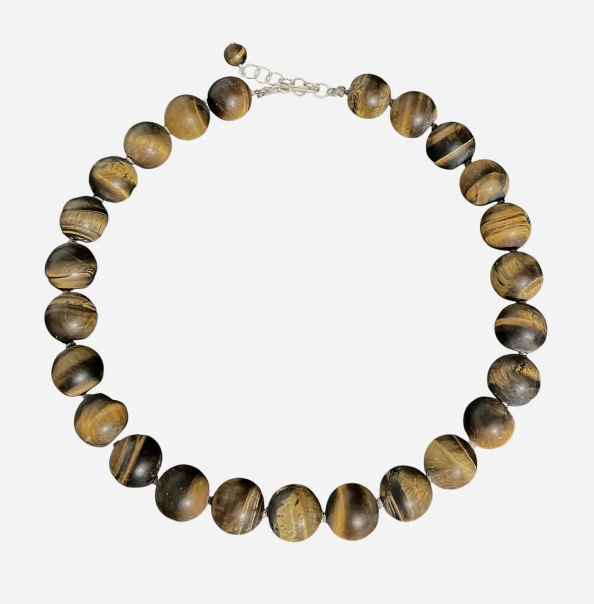 The ANN LIGHTFOOT Matte Tiger Eye Ras du Cou Necklace features round matte brown gemstone beads with unique natural patterns, strung in a single strand and finished with a sterling silver clasp and extender for an adjustable fit.