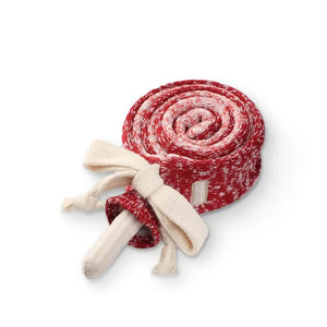 The LAMBWOLF COLLECTIVE - LOLLIPOP DOG TOY by LAMBWOLF COLLECTIVE features a red and white speckled rope neatly coiled into a lollipop shape, with the ends tied in a white knot resembling a bow. The stick of the lollipop is positioned at the bottom, maintaining its playful design. This charming dog toy adds a whimsical touch to any setting.