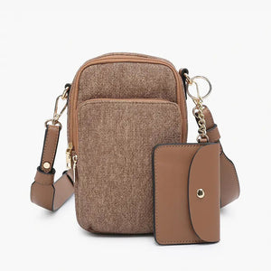 The PARKER DENIM CROSSBODY by JEN & CO is a compact, brown bag featuring multiple pockets and zippers, paired with a matching brown cardholder, ideal for enhancing any fall wardrobe with style. The bag includes a gold keyring attachment and an adjustable strap, both elegantly arranged against a simple backdrop.