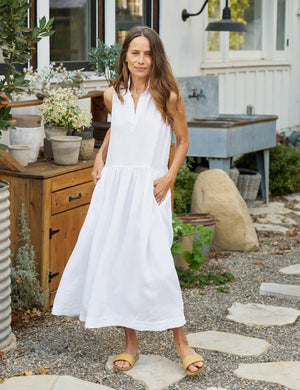 The FRANK & EILEEN - DAPHNE SLEEVELESS POPOVER DRESS is a sophisticated maxi dress in washed linen, featuring a collar and V-neck. This elegant dress by FRANK & EILEEN showcases a fitted bodice, a gathered flared skirt, and convenient side pockets. It is displayed against a white background.