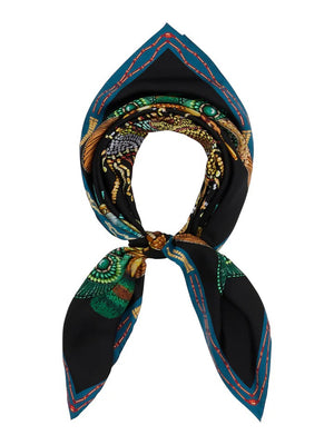 A black, intricately patterned silk 90x90 carré foulard from FRANCO FERRARI, designed with green and gold elements, folded into a triangle and tied with a knot, featuring a teal and red border and handrolled hem.